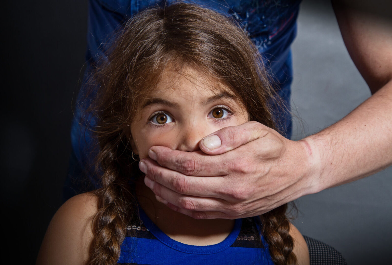 A girl with her hands over her mouth.