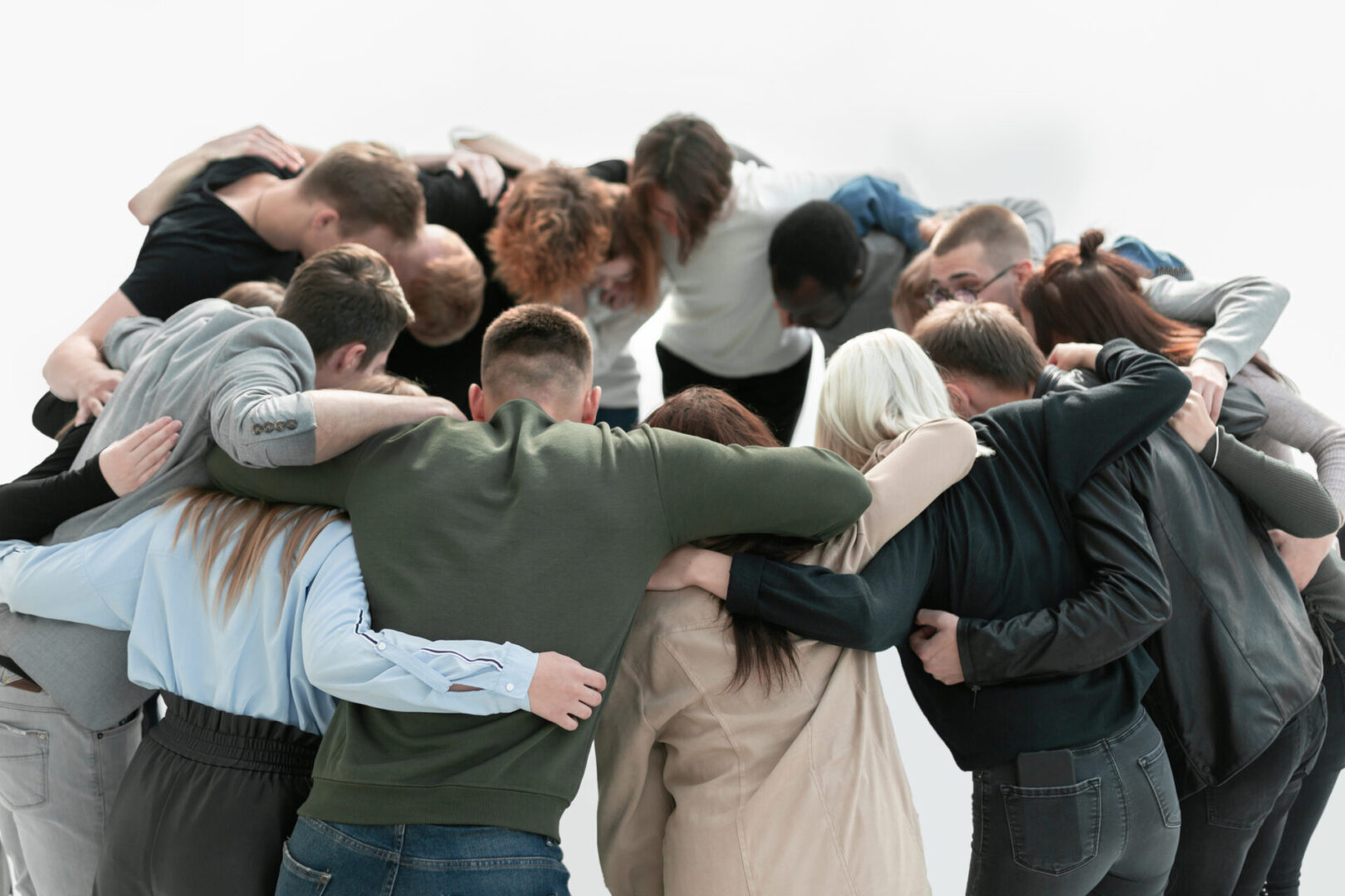 A group of people huddle together in the middle of a field.