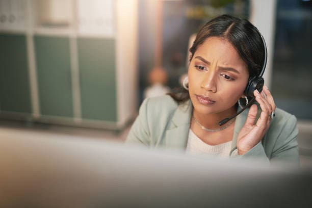 A woman sitting at her desk looking down.