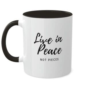 A black and white mug with the words live in peace not pieces written on it.