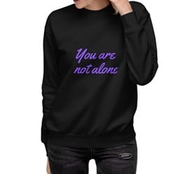 A woman wearing a black sweatshirt with the words " you are not alone ".