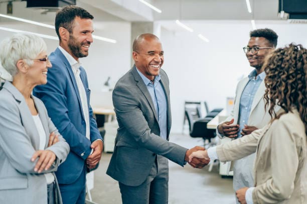 A group of people shaking hands in an office.