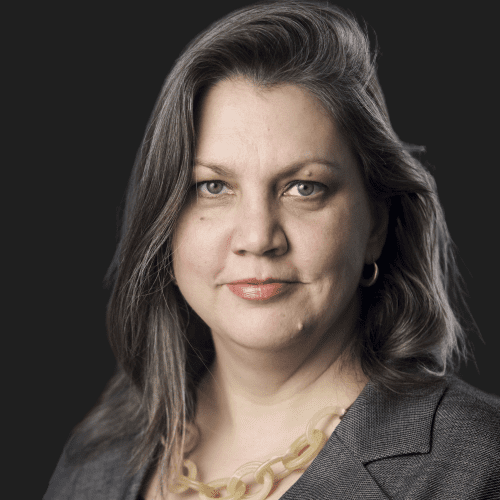 A woman with long hair wearing a gray jacket.