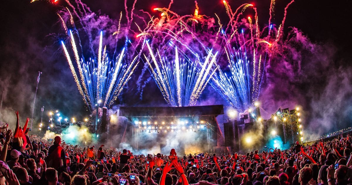 A crowd of people watching fireworks at night.