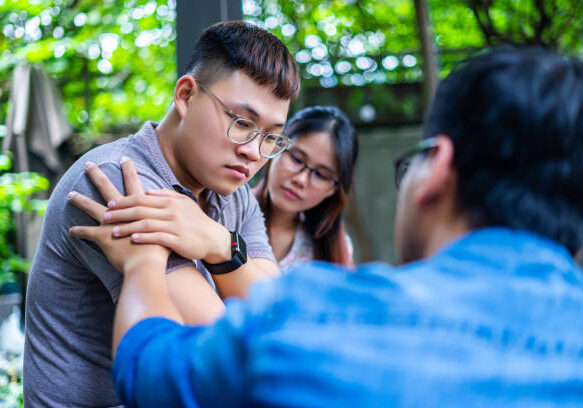 A man and woman are holding hands in front of another person.